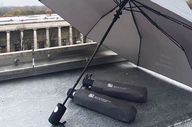 grauer Regenschirm mit Logo "leben bauen bewegen"