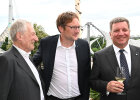Hier sind 3 Männer in Anzügen zu sehen, im Hintergrund das Olympiadach. Von links nach rechts: Architekt Prof. Fritz Auer, Landrat Dr. Hans Reichhart Staatsminister Christian Bernreiter