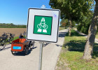 Verkehrszeichen Fahrradschnellweg, im Hintergrund Fahrräder auf einem Radweg