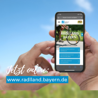 Im Vordergrund ein Smartphone, das von einer Hand gehalten wird. Auf dem Display ist die neue Internetseite zu sehen. Im Hintergrund unscharf blauer Himmel und eine Blumenwiese. Text: Jetzt online: www.radlland-bayern.de