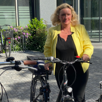 Kerstin Schreyer stellt ein Fahrrad ab
